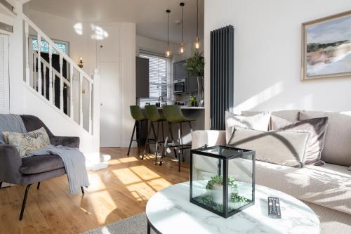 a living room with a couch and a table at Beautiful Mews Cottage near Brighton Seafront in Rottingdean Village in Rottingdean
