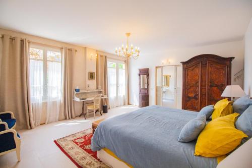 a bedroom with a large bed with yellow pillows at Domaine de la Cascade Parfumée in Grasse