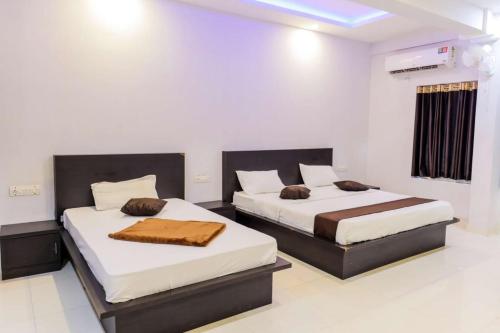 two beds in a room with white walls at Igloo Residency in Vythiri