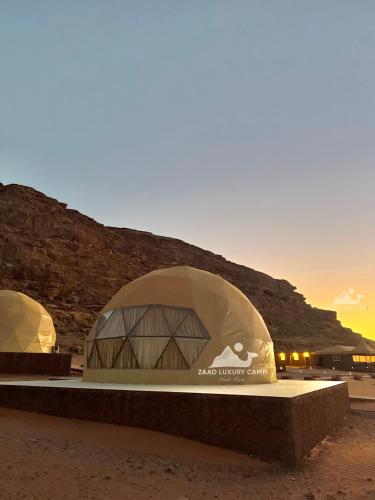 a building in the desert with the sunset in the background at Wadi Rum ZAAD luxury Camp in Disah