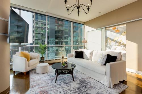 a living room with a white couch and a table at 2Bed DT-Mountain & Skyline Views- Colours 1st-BMO in Calgary