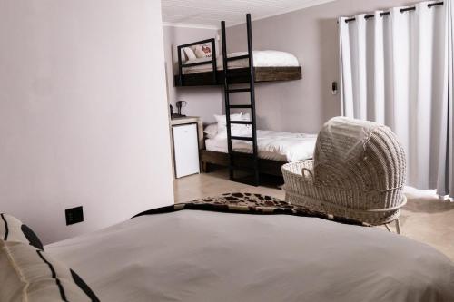 a bedroom with bunk beds and a chair and a bed at Farmco Marloth Park in Marloth Park