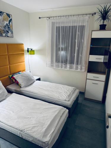 a room with two beds and a window at Apartament Nad Nielbą in Wągrowiec