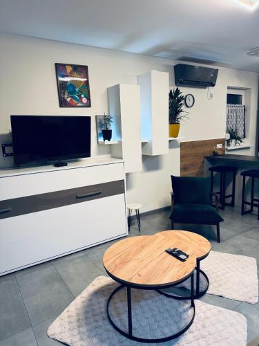 a living room with a table and a tv at Apartament Nad Nielbą in Wągrowiec