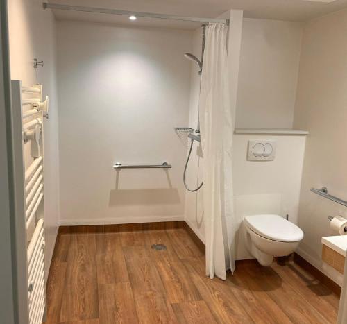 a white bathroom with a toilet and a shower at Zenao Appart'hôtels Dijon in Dijon
