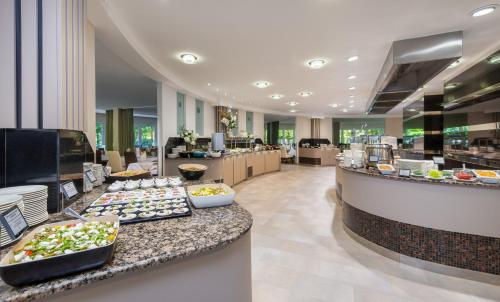 a buffet line with food on display in a restaurant at Lotus Therme Hotel & Spa in Hévíz