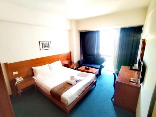 a hotel room with a bed and a chair at Caesar's Park Hotel in Beirut
