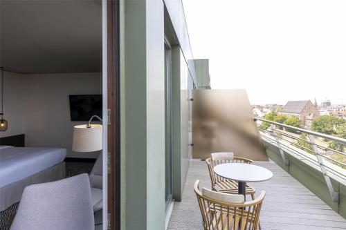 a room with a balcony with a table and chairs at Scandic Nürnberg Central in Nürnberg