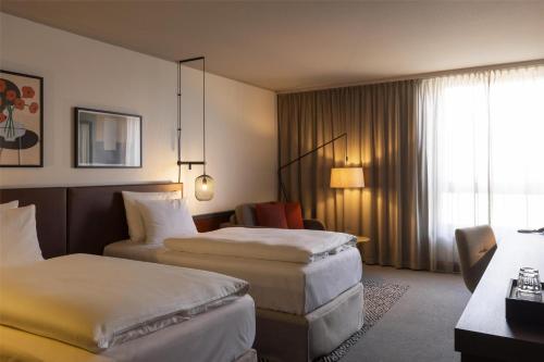 a hotel room with two beds and a window at Scandic Nürnberg Central in Nürnberg