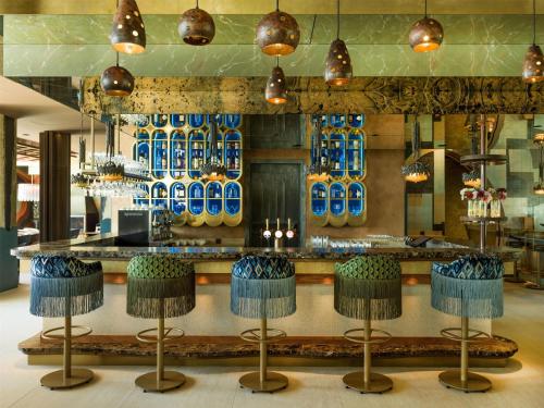 a bar with blue glasses on the wall at Radisson Collection The National Hotel, Brussels in Zaventem