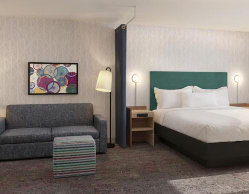 a hotel room with a bed and a couch at Home2 Suites By Hilton Hickory in Hickory