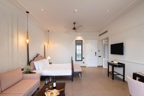 a bedroom with a bed and a couch and a tv at The Haven by Sula in Nashik