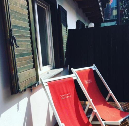 two red chairs sitting next to a window at Albergo Aprica Garni in Aprica