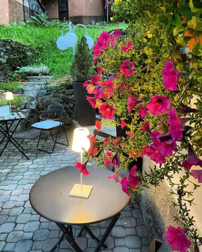 a table with pink flowers on a patio at Albergo Aprica Garni in Aprica