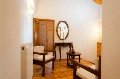 a living room with a chair and a mirror at Villa Kirke with private swimming pool in Próvarma