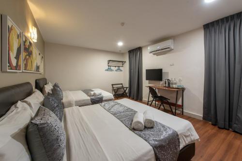 a hotel room with two beds and a desk at Hotel Sunjoy9 OKR in Kuala Lumpur