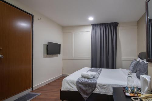 a hotel room with a bed and a tv at Hotel Sunjoy9 OKR in Kuala Lumpur