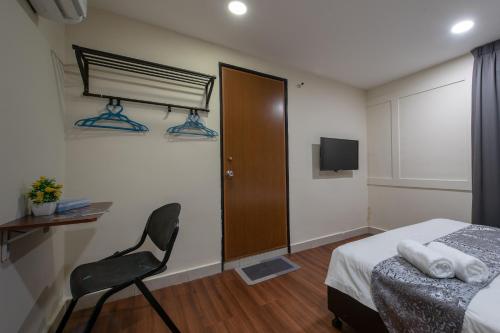 a bedroom with a bed and a chair and a television at Hotel Sunjoy9 OKR in Kuala Lumpur