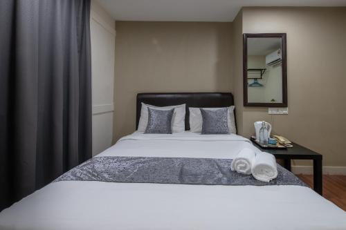 a bedroom with a large bed and a mirror at Hotel Sunjoy9 OKR in Kuala Lumpur