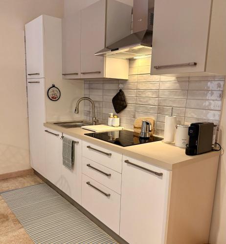 a kitchen with white cabinets and a sink at Twin Homes - Tamerò Estates in Poggio Mirteto