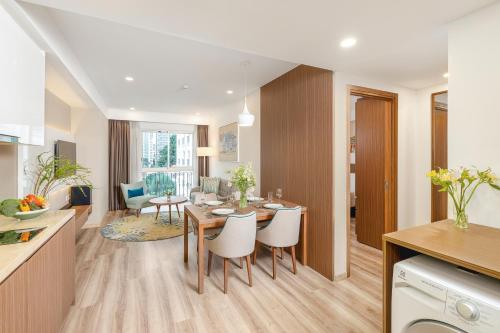 a kitchen and living room with a table and chairs at T-Ritz Saigon Hotel & Apartment in Ho Chi Minh City