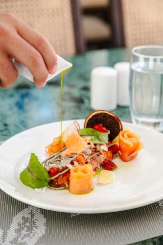 a person is pouring cheese onto a plate of food at NearYo Hotels in Marrakech