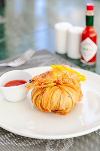 a plate with a croissant and a bowl of sauce at NearYo Hotels in Marrakech