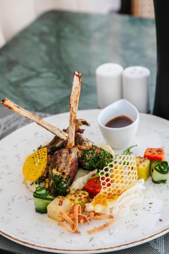 a plate of food with meat and vegetables on a table at NearYo Hotels in Marrakech