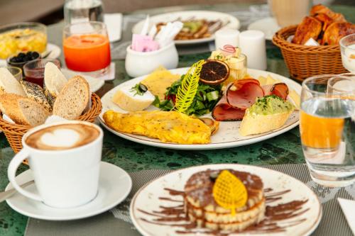 a table with plates of breakfast foods and a cup of coffee at NearYo Hotels in Marrakech
