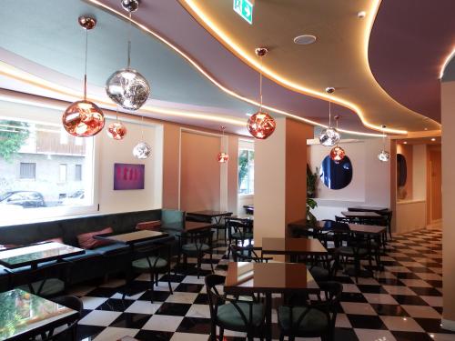 a restaurant with tables and chairs and a ceiling with lights at Hotel Morfeo in Milan