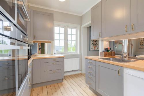 a kitchen with white cabinets and a sink at Åre Travel - Villa Årebo in Åre