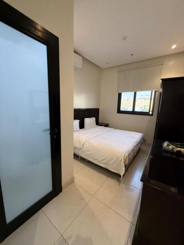 a bedroom with a bed and a large window at Room in Aread in Riyadh