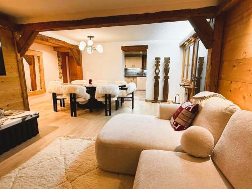 Megève centre في ميجيف: غرفة معيشة مع أريكة وطاولة مع كراسي