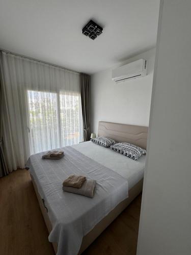 a bedroom with a bed with two towels on it at Apartman Severny Cyprus in Iskele
