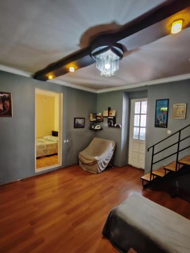 een woonkamer met een bed en een kroonluchter bij two story house in center of the tbilisi in Tbilisi City