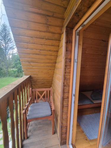 a wooden porch with a chair on a deck at Chata Kemp in Tatranska Strba
