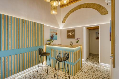 Una habitación con dos sillas y una barra con una pared. en VFH La Rada Apartments, en Santa Flavia