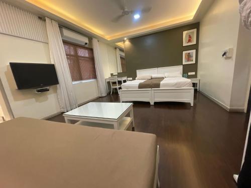 a living room with two beds and a tv at Hotel Ketan in Pune