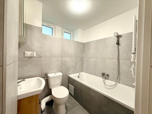 ソポトにあるPrzestronne mieszkanie przy plaży - Kordeckiego 8のトイレ、浴槽、洗面台を備えたバスルーム