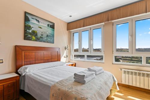 a bedroom with a bed and windows at Santa Divina Relax Para 10 Personas in Naveces