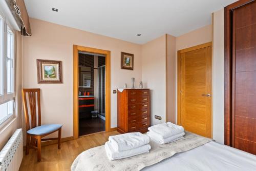 a bedroom with a bed and a chair and a dresser at Santa Divina Relax Para 10 Personas in Naveces
