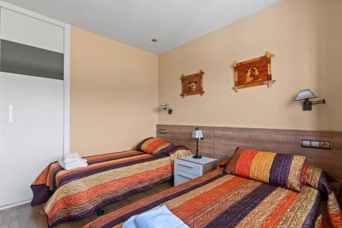 a bedroom with two beds and a mirror at Santa Divina Relax Para 10 Personas in Naveces