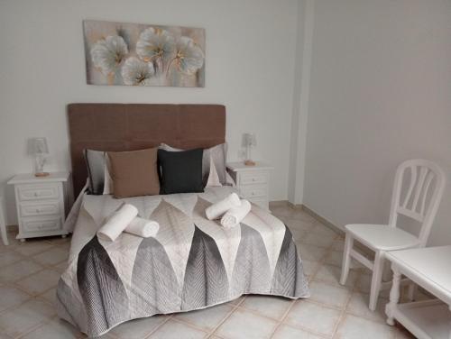 a bedroom with a bed and a white chair at Susurro del Mar - Relax Apartment in La Restinga in La Restinga