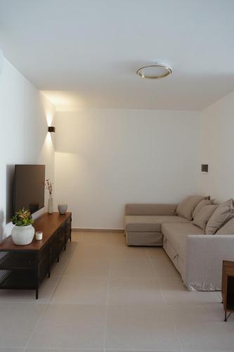 a living room with a couch and a table at Bright Spacious Apartment in the Heart of Malta in Is-Simblija