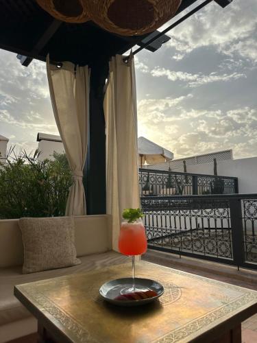 a drink sitting on a table on a balcony at Riad Jonan & Spa in Marrakech