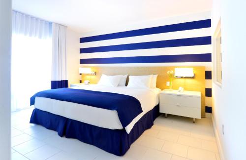 a bedroom with a large bed with blue and white stripes at Pestana South Beach Hotel in Miami Beach