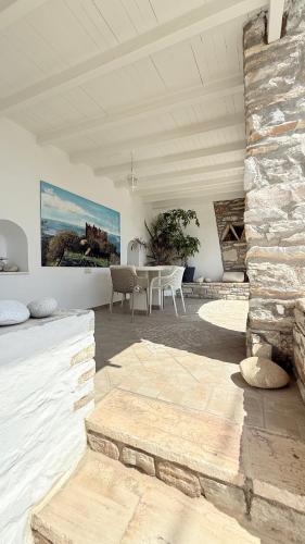 a living room with a table and a stone wall at Naxos Dream Oniro Studios - Adults Only in Naxos Chora