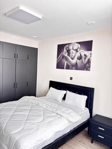 a bedroom with a bed and a picture on the wall at Stay with queen in Marimbeti