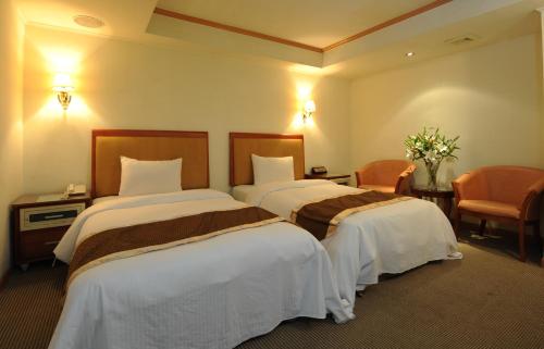 a hotel room with two beds in a room at Wonderful Hall Hotel in Xinzhuang