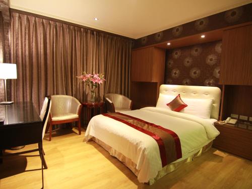 a bedroom with a large bed and a desk and a desk at Wonderful Hall Hotel in Xinzhuang